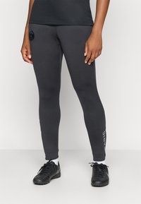 Szürke leggings, rugalmas anyagból, fekete logóval a csípőn és a "PARIS" felirattal fehér színben az alsó lábszáron.