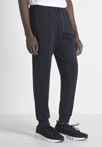 Marine jogger broek gemaakt van een zachte stof, met een elastische tailleband met een trekkoord, zijzakken en ribgebreide boorden bij de enkels.