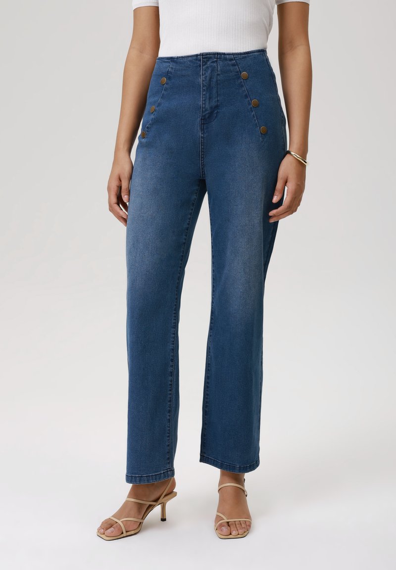 High-waisted denim broek in donkerblauw met voorste knoopaccenten, rechtpijpenontwerp en minimale vervaging. Gladde textuur en klassieke stijl.