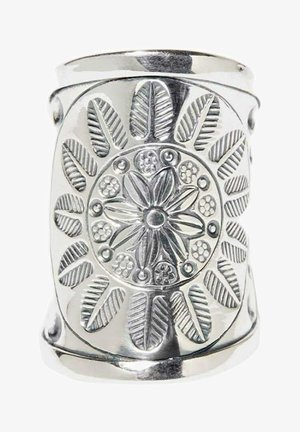 Large bague en argent avec des motifs de fleurs et de feuilles gravés formant un dessin circulaire autour du centre.