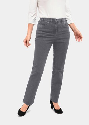 Jean en denim gris avec une coupe droite, taille haute, design à cinq poches et texture subtile, associé à des chaussures à talons hauts noires.