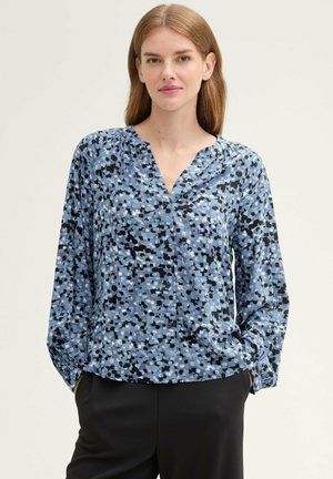 Long-sleeve blouse in light blue with black and white abstract patterns, featuring a V-neck and button details at the front.