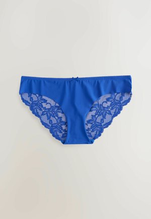 Culotte bleu avec un devant uni et des côtés en dentelle complexe au motif floral et aux bords festonnés. Détail en forme de petit nœud au centre.