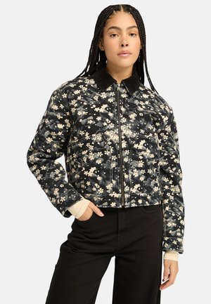 Floral patterned black denim jacket with a cropped design, silver zipper, and corduroy collar; features front pockets and textured fabric.