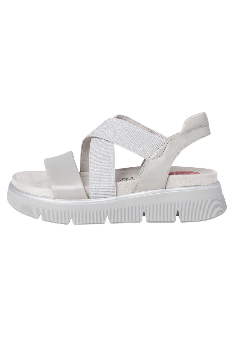 Ljust grå sandal med korskorsade remmar, ett strukturerat elastiskt band och en vadderad sula. Utrustad med en gummisula med ribbat mönster.