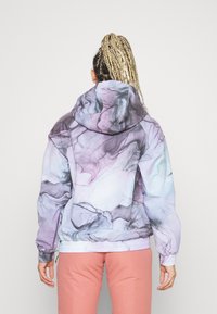 Veste à capuche avec un motif marbré pastel en violet, rose et bleu clair. Poignets et ourlet élastiques, avec une coupe décontractée et des poches zippées.