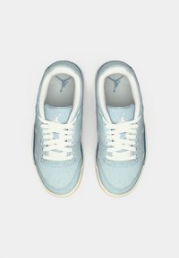 Baskets en denim bleu avec des lacets blancs et des semelles en caoutchouc. Présentant un dessus en coton et un intérieur bleu clair avec un logo sur la languette.