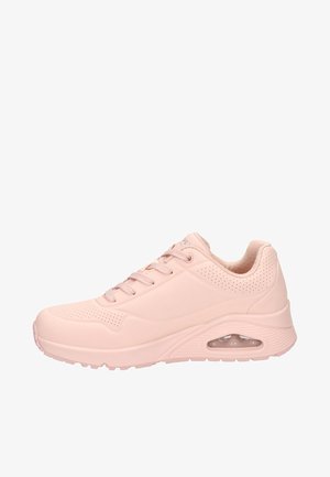 Zapatilla deportiva rosa con un upper suave similar al cuero, detalles perforados, diseño de cordones y un cojín de aire visible en el talón.