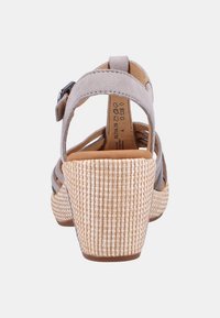 Harmaa mokkasiinipohjallinen sandaali avonaisella takana, punottu olkipohja, säädettävä hihna ja sileä nahkasisus.