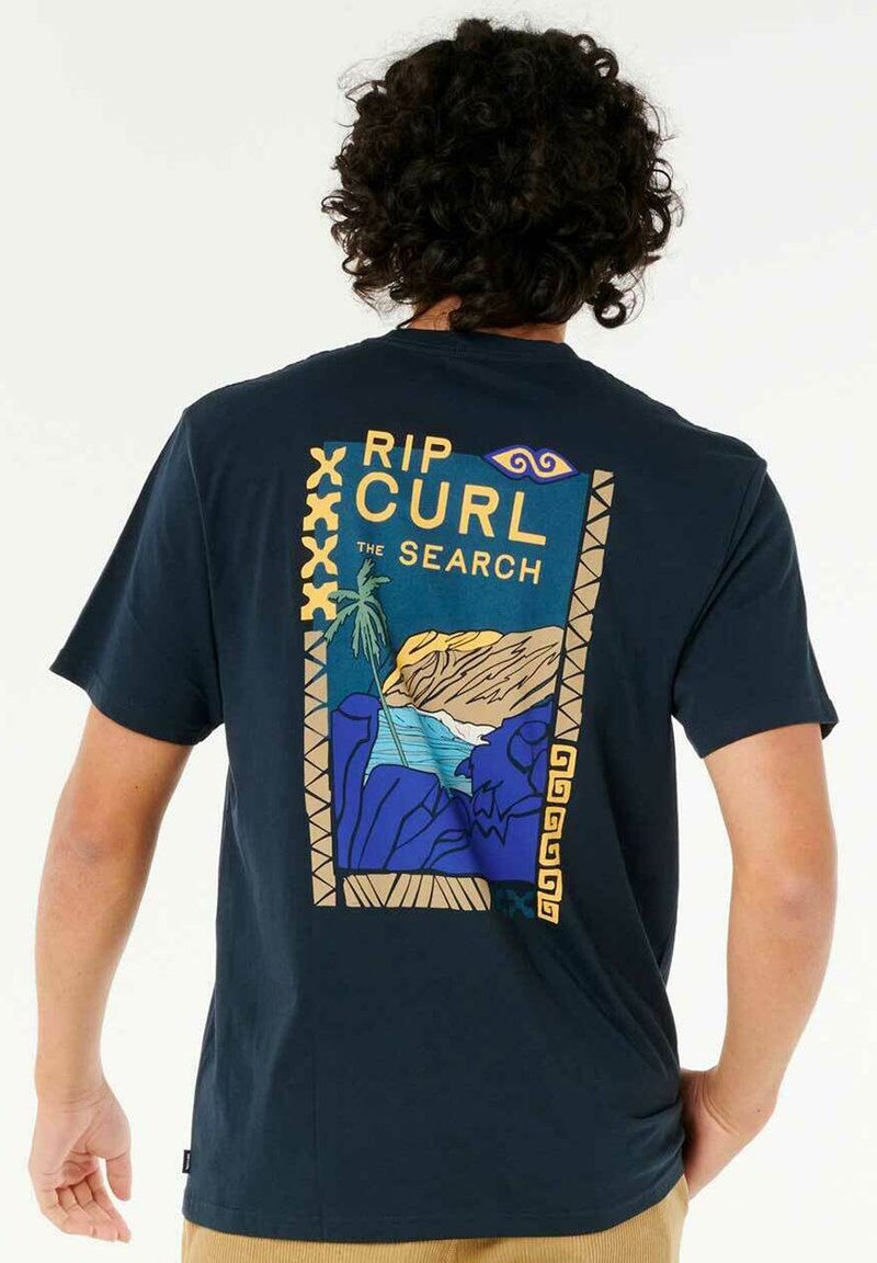 Mørkeblå t-shirt med grafisk print på ryggen, der viser palmer, bjerge og hav i livlige farver, samt teksten "RIP CURL THE SEARCH".