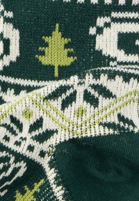 Πλεκτό πουλόβερ με σκούρο πράσινο χρώμα, διακοσμημένο με λευκά και ανοιχτοπράσινα φύλλα, υφασμένους πόντους και αντιθετικά γεωμετρικά σχέδια.