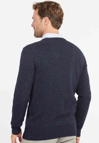 Navy blue sweater with a textured knit, round neckline, ribbed cuffs, and hem. Features subtle speckles of color throughout.