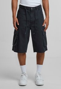 Dark navy cargo shorts made of durable fabric, featuring a relaxed fit, multiple side pockets, and drawstring closure. Worn with white sneakers.