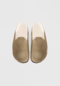 Tan suede clogs with a soft inner lining, rounded toe, and cutout design. Features a smooth texture and black rubber sole.