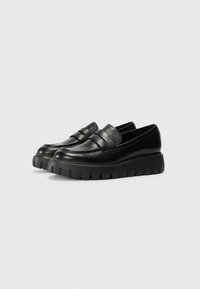 Black leather loafers with a thick, ridged sole and a textured band at the top. Smooth finish with no visible hardware or accents.