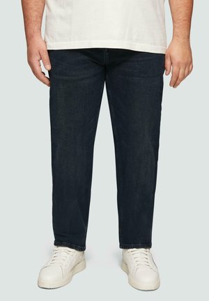 Donkerblauwe denim jeans met een recht model, voorzien van een subtiele textuur, een traditionele vijf-pocket ontwerp en gecombineerd met witte sneakers.