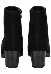 Stivali alla caviglia in suede nero con tacco alto. Presentano una zip laterale e una texture liscia. Il tacco ha un design rigato per una presa aggiuntiva.