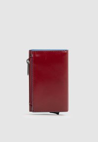 Portafoglio in pelle rossa con una tasca con zip, accento blu lungo la parte superiore, forma rettangolare, texture liscia e cuciture visibili.