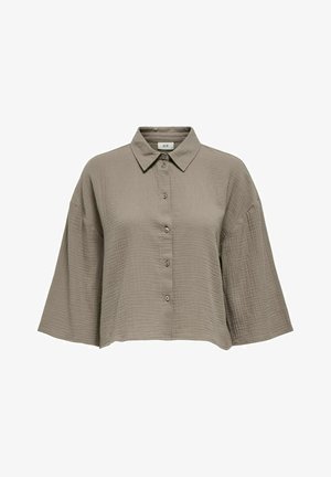 Blouse à manches courtes et col, de couleur marron atténuée, fabriquée à partir d'un tissu texturé avec un devant boutonné et une coupe oversize.