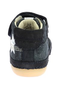 Zapato de ante azul oscuro con un acento de estrella blanca, cierre con tira de velcro y suela de goma ligera. Detalle sutil de purpurina en la superficie.