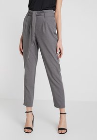 Grijze op maat gemaakte broek met hoge taille, textuurstof, riemdetail in de taille en cropped, taps toelopende pijpen. Zwarte open-toe hakken.