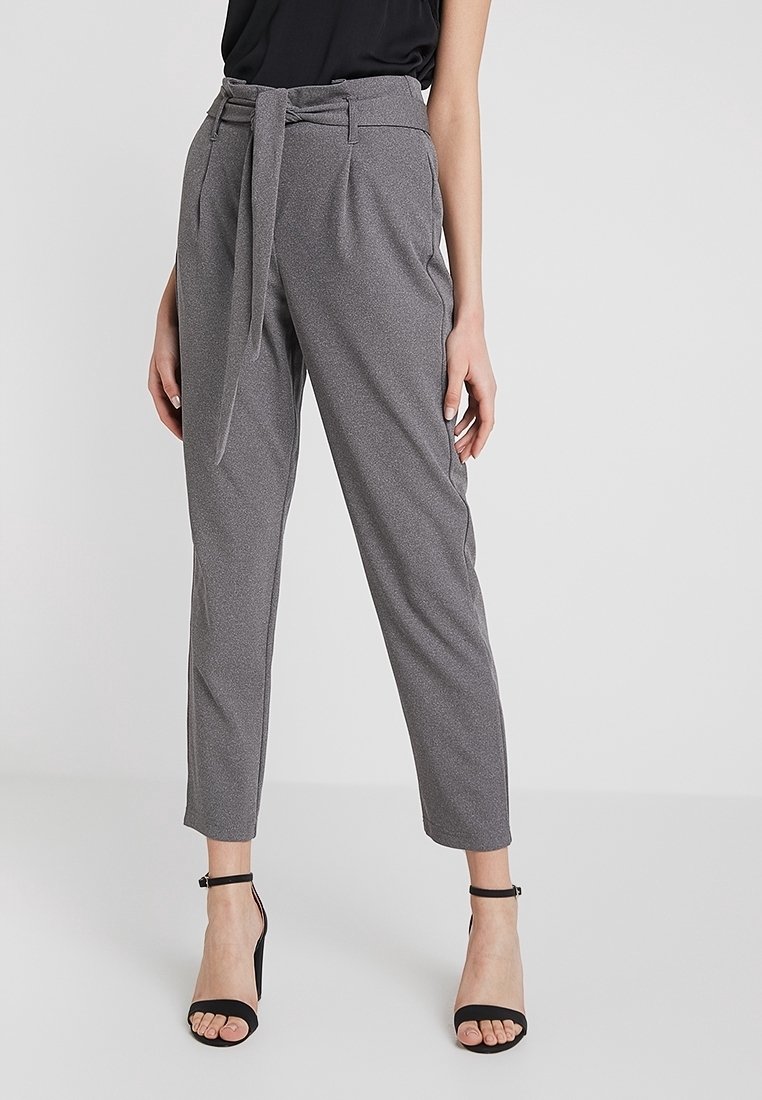 Grijze op maat gemaakte broek met hoge taille, textuurstof, riemdetail in de taille en cropped, taps toelopende pijpen. Zwarte open-toe hakken.