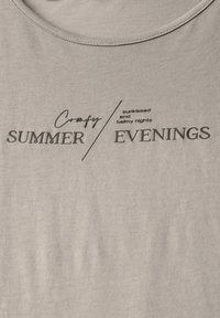Lichtgrijze katoenen t-shirt met zwarte bedrukte tekst: "Comfortabele ZOMER/Avonden" en "door de zon gekuste en zachte nachten." Glad van textuur. Ronde halslijn.