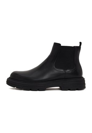Bota Chelsea de cuero negro con panel lateral elástico, lengüeta en el talón y suela gruesa y resistente, mostrada de perfil sobre fondo blanco.