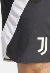 Shorts sportivi neri con pannello laterale bianco, dotati di una texture in rete. Presentano un logo bianco sull'orlo per il branding.