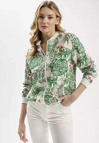 Jacket na zamek błyskawiczny z tropikalnym wzorem w zielone liście i czerwone kwiaty. Miękka tkanina z prążkowanym kołnierzem i mankietami.