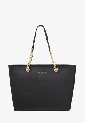 Czarna skórzana torba typu tote z złotymi łańcuchowymi uchwytami i logo „Michael Kors” umieszczonym na środku z przodu.