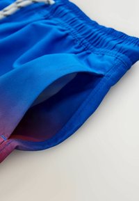 Șort de baie albastru cu talie elastică, textură netedă și o tranziție în degrade spre mov la tiv, cu detaliu de buzunar lateral.