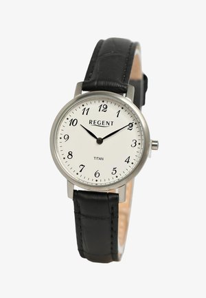 Boîtier de montre en acier inoxydable argenté rond avec cadran blanc, chiffres arabes noirs et bracelet en cuir noir à finition texturée.