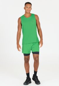 Groene sportieve tanktop en short set, gemaakt van vochtafvoerende stof; heeft een subtiel patroon en contrasterende zwarte accenten.