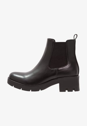 Botas Chelsea de cuero negro con paneles laterales elásticos, punta redonda y un tacón grueso con una suela texturizada.