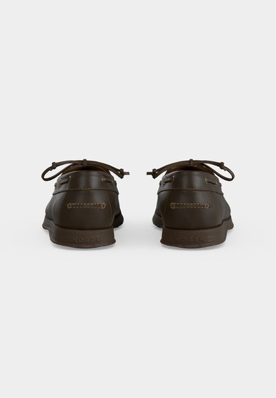 Paire de chaussures bateau en cuir marron foncé avec des détails cousus et des lacets, vue de dos sur un fond clair uni.
