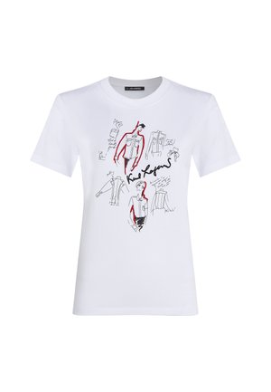 Vit bomull t-shirt med svarta och röda konstnärliga skisser av plagg och figurer, med handskrivna anteckningar och signaturer.