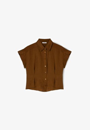 Camicia marrone a maniche corte con bottoni, colletto, pince anteriori e orlo leggermente svasato, stesa su uno sfondo bianco.