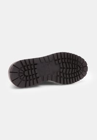 Semelle de chaussure en caoutchouc noir avec des crampons profonds pour la traction, présentant un bord lisse et un logo embossé au centre. Le design met l'accent sur la durabilité.