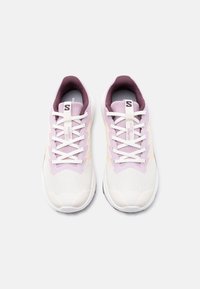 Ζευγάρι λευκά και ανοιχτό μωβ αθλητικά παπούτσια με λευκά κορδόνια, σε θέαση από πάνω σε λευκό φόντο.