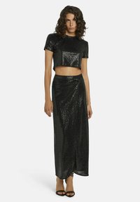 Zwarte pailletten crop top met een ronde hals, gecombineerd met een hooggesneden, vloerlange rok met een gedraaide detail en een zijsplit.