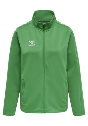 Chaqueta verde con cremallera fabricada en tejido suave, con un alto cuello y dos bolsillos laterales. Acentuada con un logo blanco y franjas en los hombros.