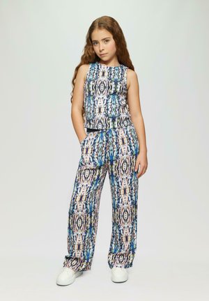 Ensemble coloré en deux pièces comprenant un haut sans manches et un pantalon à jambes larges. Le tissu présente un imprimé abstrait vivant avec des bleus, des roses et des verts.