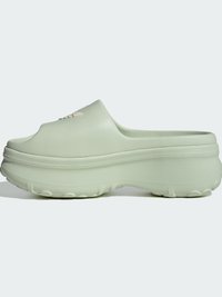 Shoe slip-on verde claro com parte superior texturizada, bicos arredondados e sola chunky; apresenta um logótipo subtil na parte da frente.