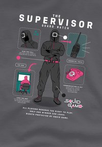 Graphic T-shirt in gray featuring a hooded figure in black, highlighted text, and illustrations of tools like a walkie-talkie and phone.