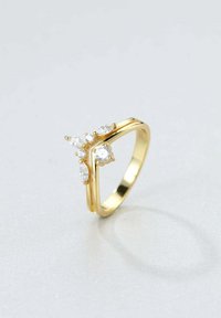 Złoty pierścionek o podzielonej obrączce, z pięcioma błyszczącymi, przezroczystymi kamieniami szlachetnymi w różnych kształtach, w tym okrągłym i marquise, osadzonymi w łapkach.