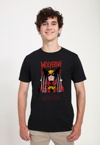 Černé tričko s barevným grafickým motivem Wolverina. Design zahrnuje drápy, text "Wolverine" a akcenty v komiksovém stylu v červené a žluté barvě.