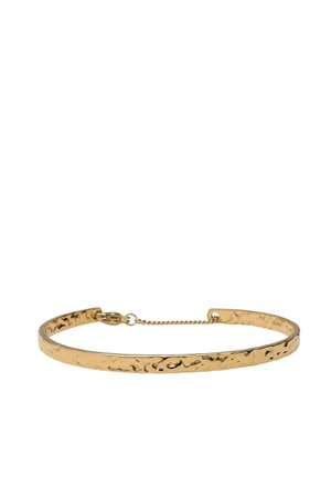 Collier ras-du-cou en or martelé fin avec une petite chaîne de sécurité et une fermeture à fermoir sur fond blanc.