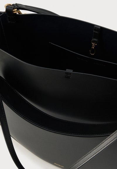 Μαύρη τσάντα tote από δέρμα με απαλό υφή, διαθέτει έναν μόνο ιμάντα και διακριτικά χρυσά μεταλλικά στοιχεία. Στο εσωτερικό έχει μια τσέπη με φερμουάρ και λογότυπο.