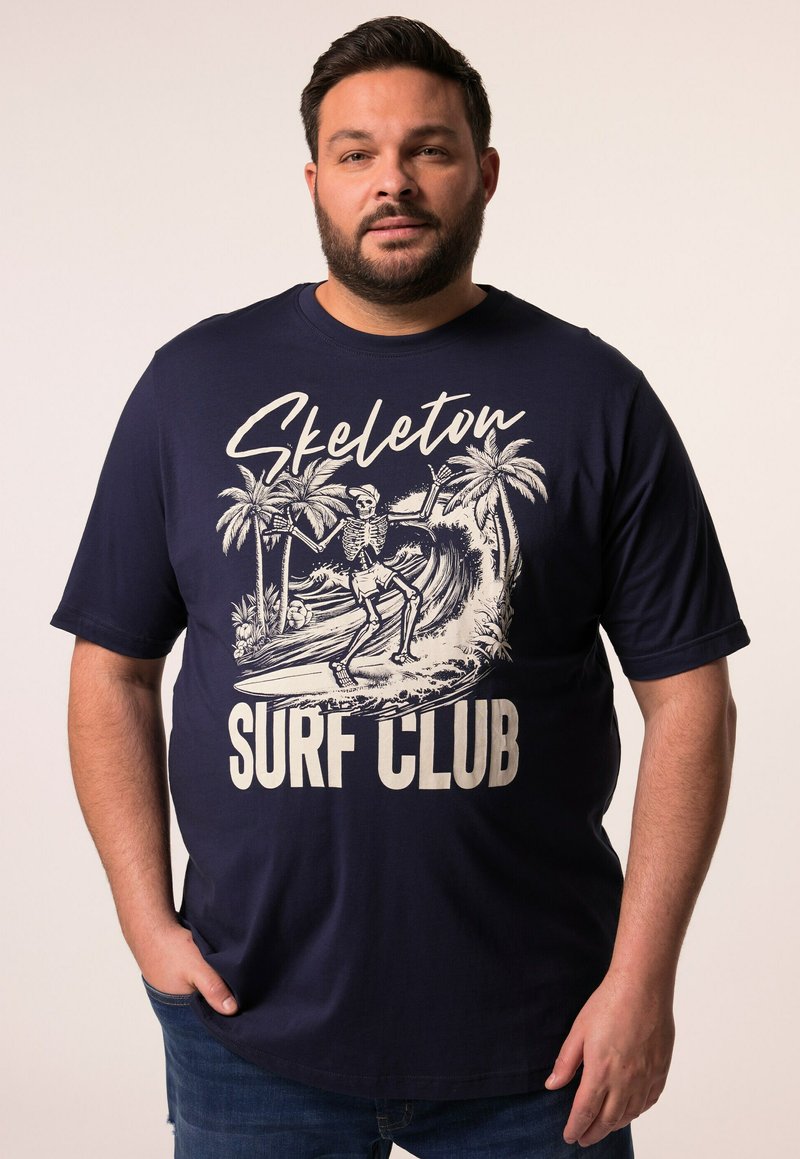 Camiseta de algodón azul marino con un gráfico de un esqueleto surfeando y palmeras, con el texto "Skeleton Surf Club" en blanco. Mangas cortas y corte holgado.